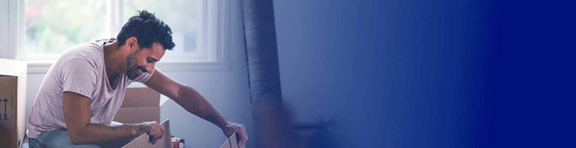 رجل يقوم بتفريغ الصناديق في منزله الجديد، بفضل تمويل أول منزل من بنك أبوظبي الأول.