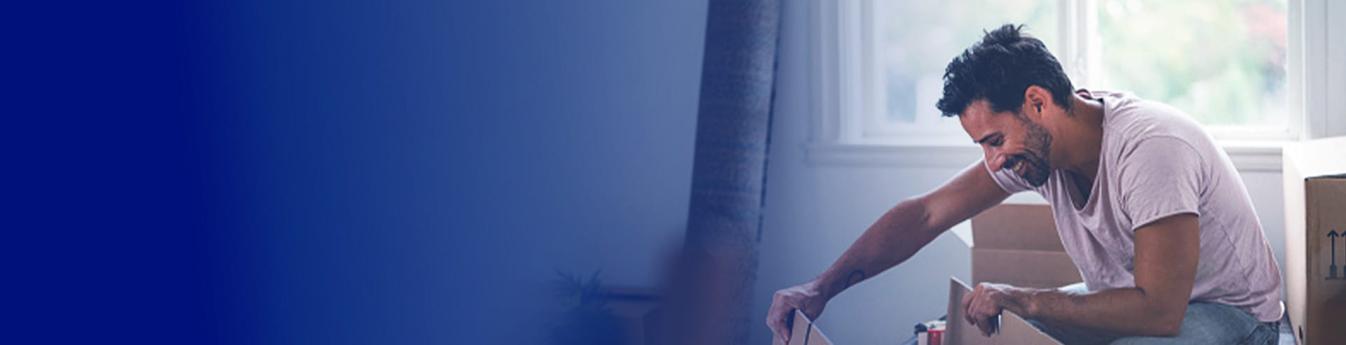 Man unpacking boxes in his new home, with a FAB first-time homeowner mortgage