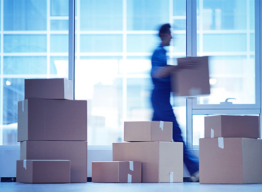 Man moving boxes, comparing buying vs. renting in UAE with FAB Mortgage.