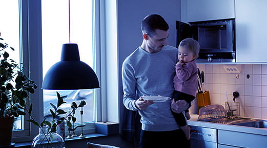 Man holding a child at home, reflecting on remortgaging with FAB.